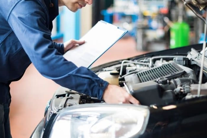 Technician checking a vehicle with service notes